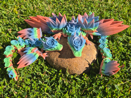 Colorful dragon-shaped toy on a stone with grass in the background